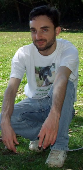 Mateus Mendes agachado, camisola branca com foto de cão Hércules.